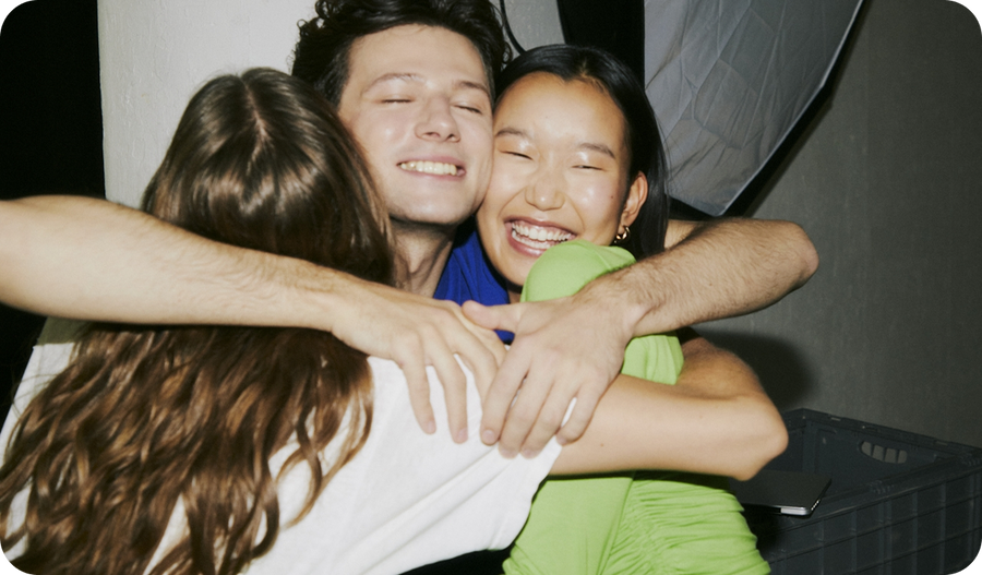 Smiling colleagues embracing in a group hug at work