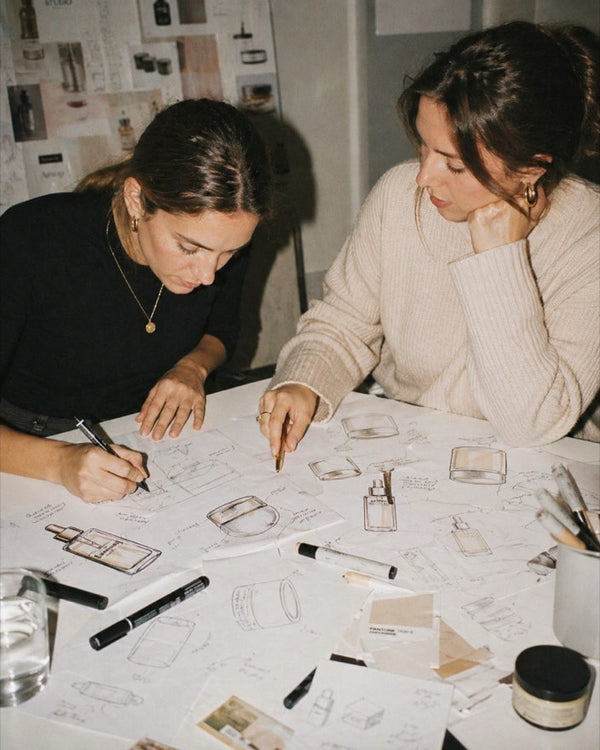 Two women sketching product design concepts together at a studio table