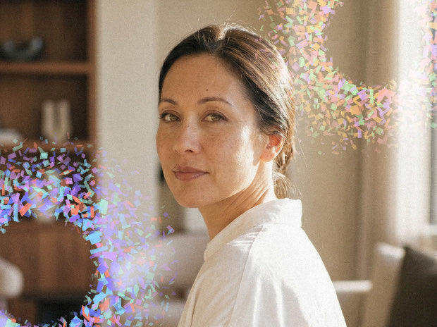 Woman surrounded by colorful particle clouds representing population-level rarity
