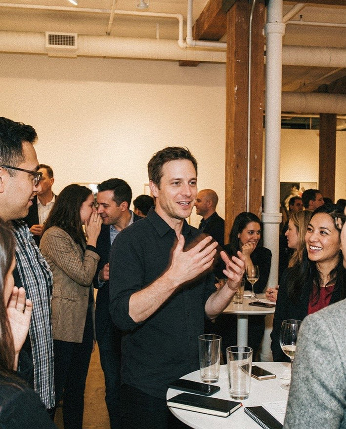 A man applauding among colleagues at a networking event, illustrating blindspots