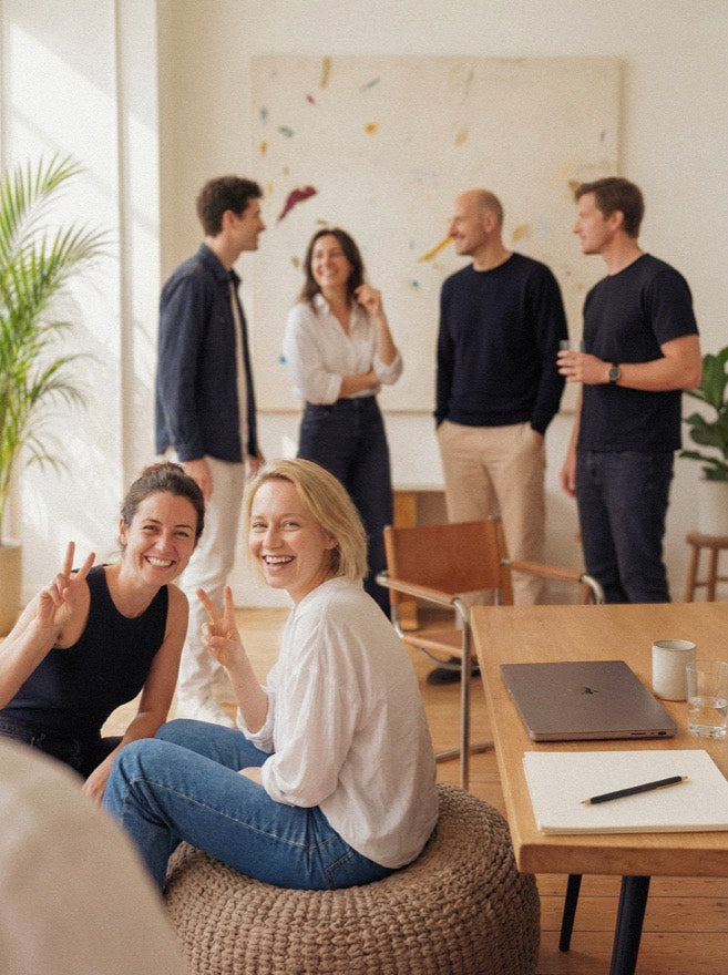 Colleagues relaxing together in a sunlit studio, illustrating the trading card section